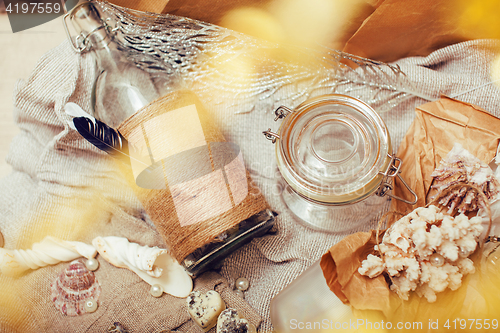 Image of a lot of sea theme in mess like shells, candles, perfume, girl stuff on linen, pretty textured post card view vintage