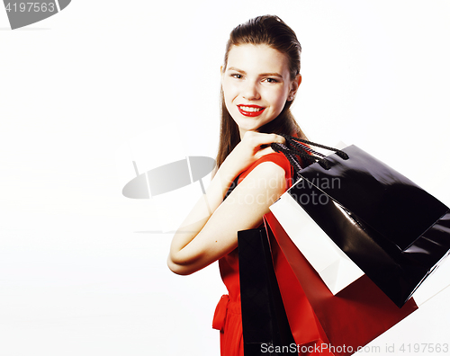 Image of young pretty smiling woman in red dress with bags on shopping isolated on white background, lifestyle real people concept 