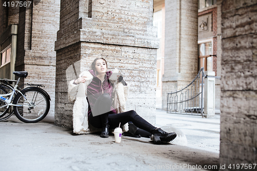 Image of young pretty stylish teenage girl outside on city street fancy f