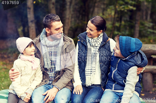 Image of happy family sitting on bench and talking at camp