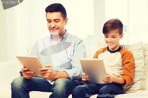 Image of happy father and son with tablet pc at home