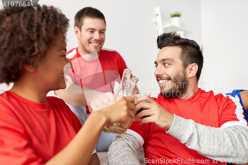 Image of happy football fans or friends with beer at home