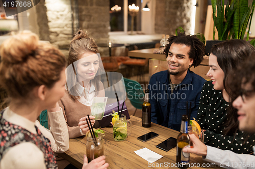 Image of friends with drinks, money and bill at bar
