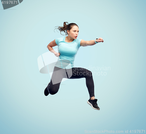 Image of happy sporty young woman jumping in fighting pose