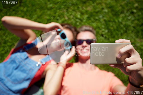 Image of happy couple taking selfie on smartphone at summer