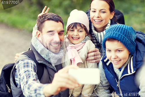 Image of family taking selfie with smartphone in woods