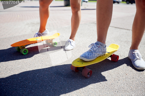Image of teenage couple riding skateboards on city street