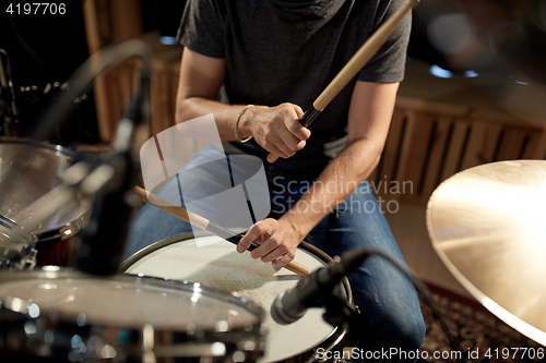 Image of male musician playing drums and cymbals at concert