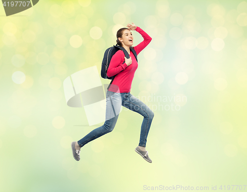 Image of happy woman or student with backpack jumping