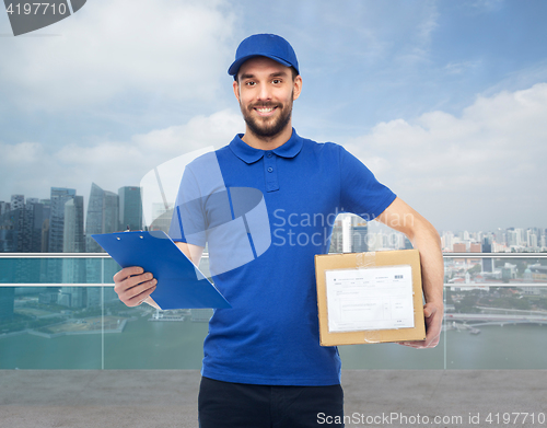 Image of happy delivery man with parcel box and clipboard