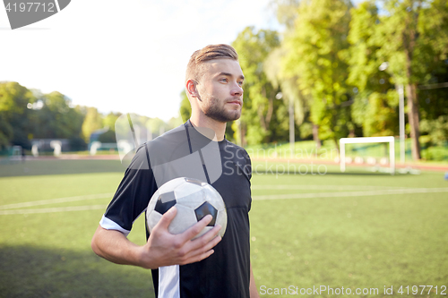 Image of soccer player with ball on football field