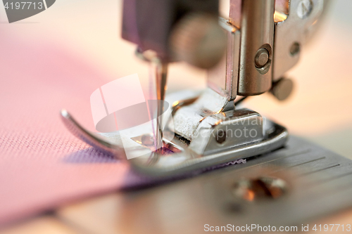 Image of sewing machine presser foot stitching fabric