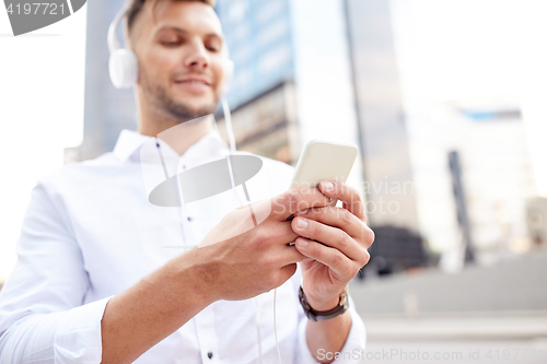 Image of man with smartphone and headphones listening music