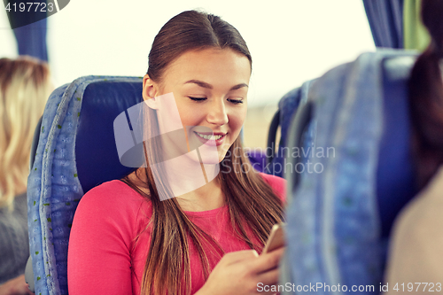 Image of happy woman sitting in travel bus with smartphone