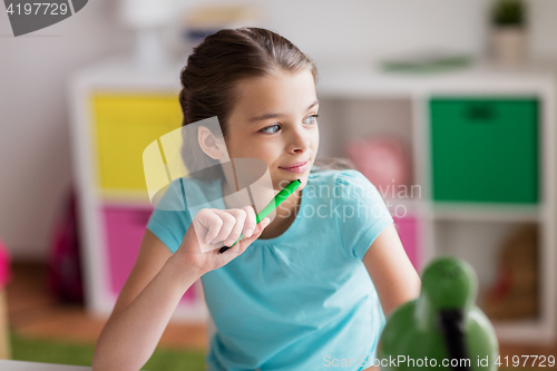 Image of happy girl with book writing to notebook at home