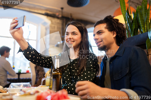 Image of happy couple taking selfie at cafe or bar
