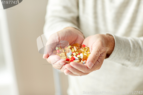 Image of close up of senior man hands holding pills