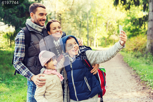 Image of family with backpacks taking selfie by smartphone