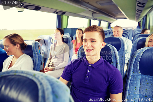 Image of happy young man sitting in travel bus or train