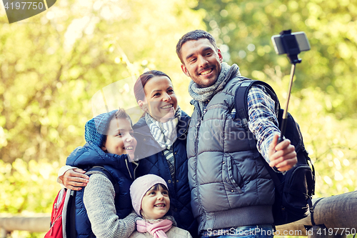 Image of happy family with smartphone selfie stick in woods