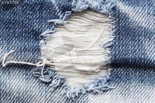 Image of close up of hole on shabby denim or jeans clothes