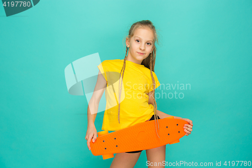 Image of Pretty skater girl holding skateboard