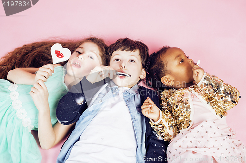 Image of lifestyle people concept: diverse nation children playing together, caucasian boy with african little girl holding candy happy smiling 