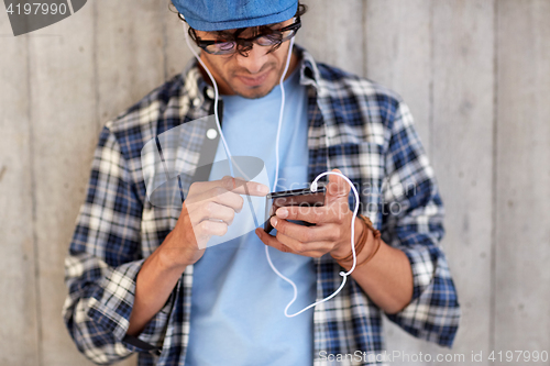 Image of man with earphones and smartphone listening music