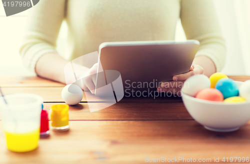 Image of close up of woman with tablet pc and easter eggs