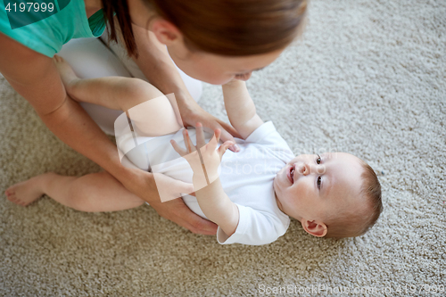 Image of happy mother playing with baby at home