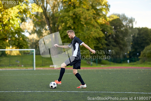 Image of soccer player playing with ball on football field