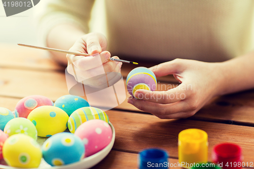 Image of close up of woman hands coloring easter eggs