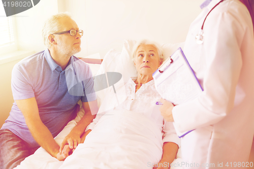 Image of senior woman and doctor with clipboard at hospital