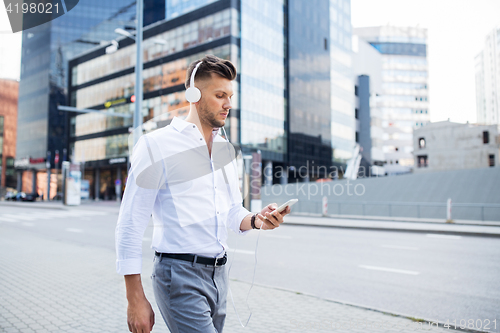 Image of man with headphones and smartphone listening music