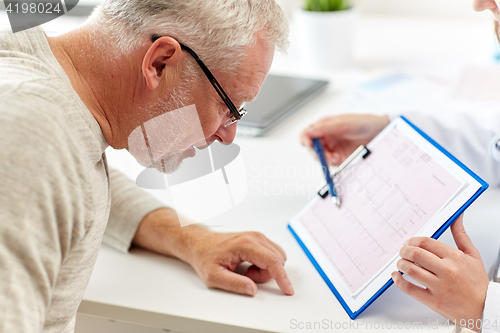 Image of doctor showing cardiogram to old man at hospital