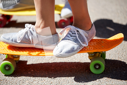 Image of close up of feet riding skateboards on city street