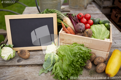 Image of close up of vegetables with chalkboard on farm