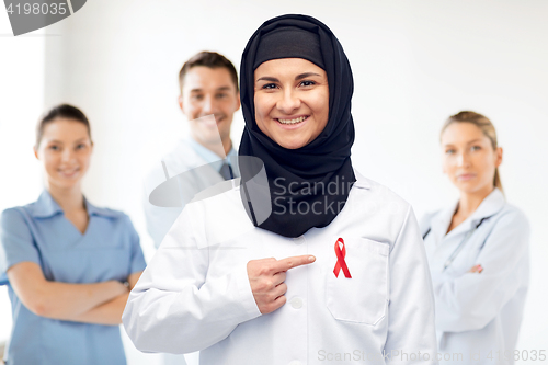 Image of muslim doctor in hijab with red awareness ribbon