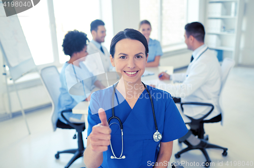 Image of happy doctor over group of medics at hospital