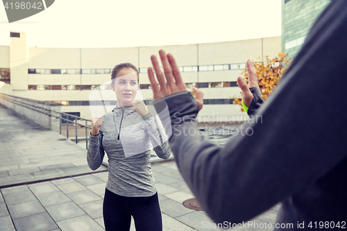 Image of woman with trainer working out self defense strike