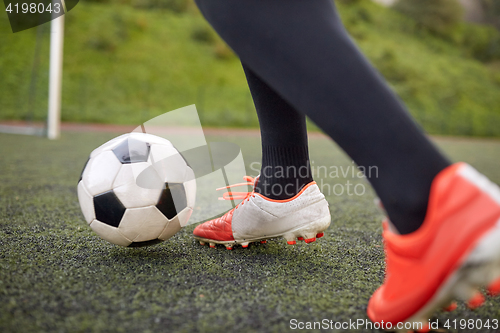 Image of soccer player playing with ball on football field