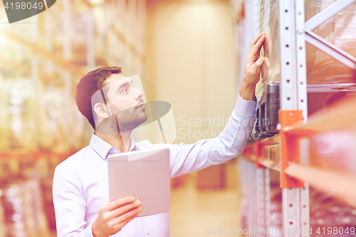 Image of businessman with tablet pc at warehouse