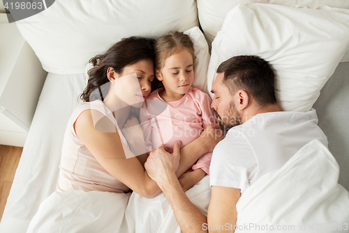 Image of happy family sleeping in bed at home