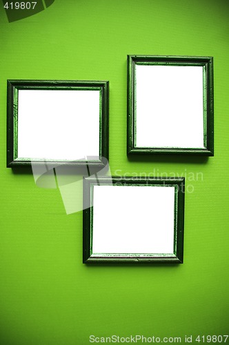 Image of empty frames on green wall