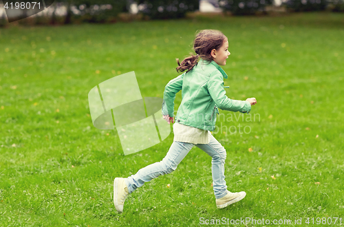 Image of happy little girl running on green summer field