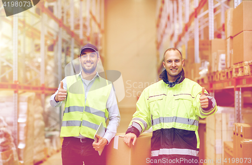 Image of men with boxes showing thumbs up at warehouse