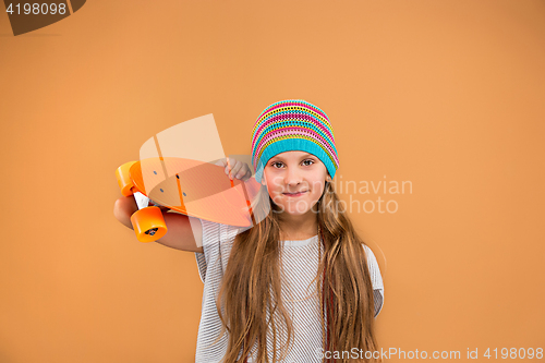 Image of Pretty skater girl holding skateboard