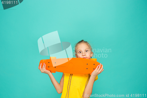 Image of Pretty skater girl holding skateboard