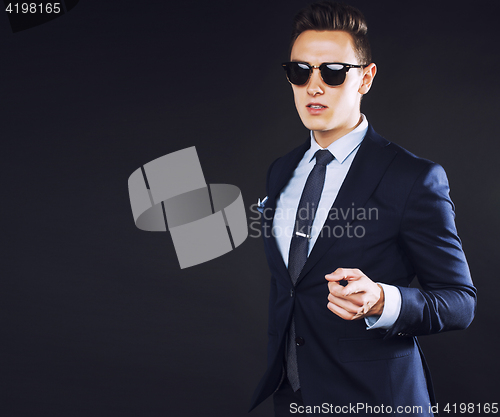 Image of young pretty business man standing on black background, modern h