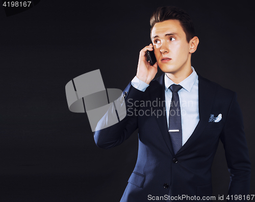 Image of young pretty business man standing on black background, modern h